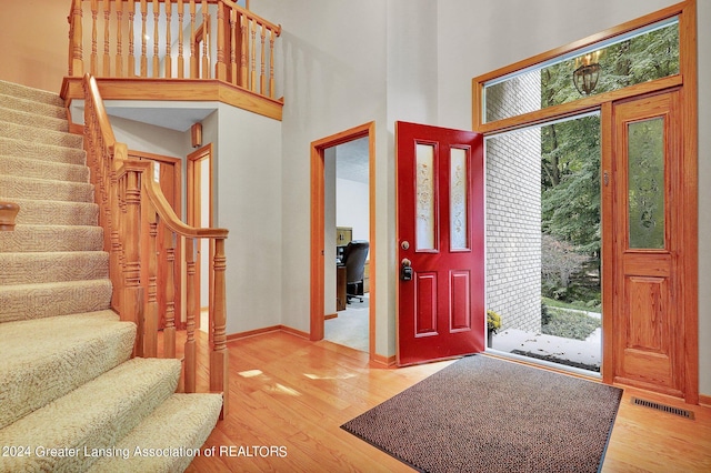 foyer featuring a towering ceiling and hardwood / wood-style flooring