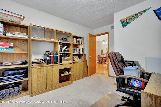 office with light carpet, a chandelier, and a textured ceiling