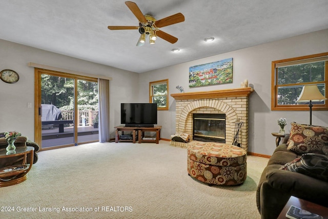 carpeted living room featuring a textured ceiling, a brick fireplace, and ceiling fan