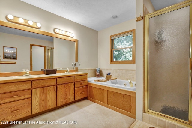 bathroom with plus walk in shower, vanity, and a textured ceiling