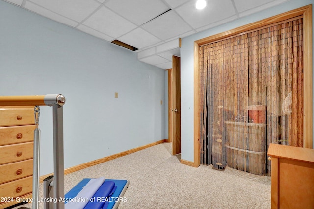 interior space with carpet flooring and a drop ceiling