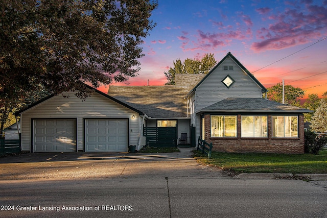 318 S Shiawassee St, Corunna, MI 48817 - traditional-style home featuring a garage, brick siding, roof with shingles, and driveway