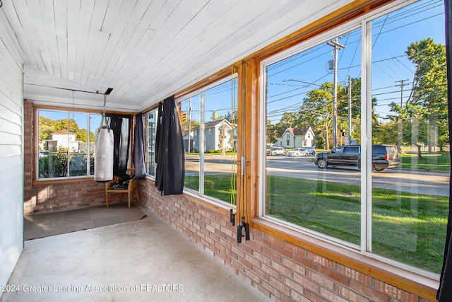 unfurnished sunroom featuring wood ceiling and a wealth of natural light