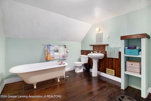 bathroom with hardwood / wood-style floors, lofted ceiling, toilet, a washtub, and sink