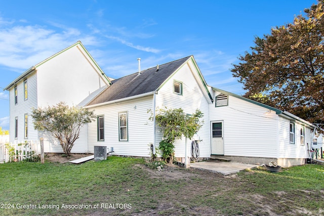 rear view of house featuring a lawn and central air condition unit