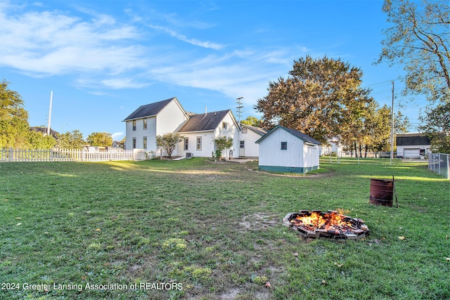 view of yard featuring an outdoor structure and a fire pit