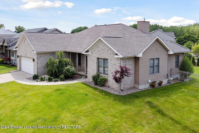 view of front of home with a front yard and a garage