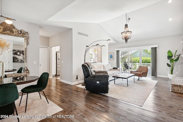 living room with a notable chandelier, dark hardwood / wood-style floors, and high vaulted ceiling