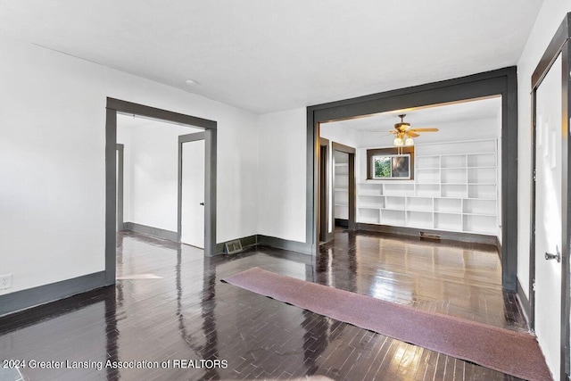 unfurnished room featuring ceiling fan and dark wood-type flooring