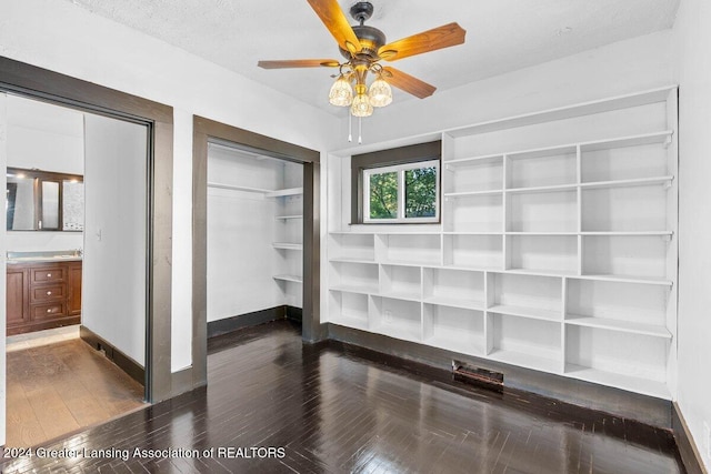 unfurnished bedroom with ceiling fan, dark wood-type flooring, and a textured ceiling