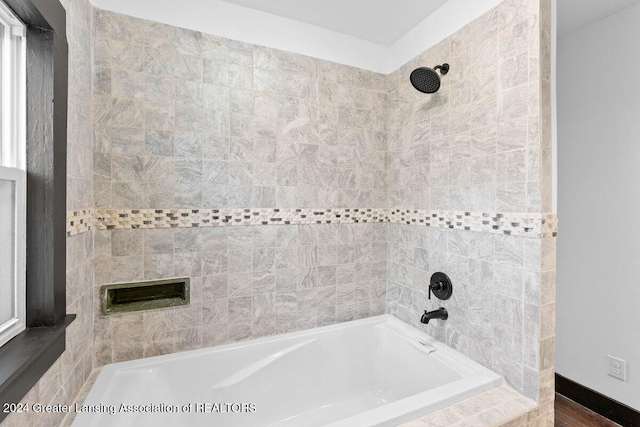 bathroom featuring tiled shower / bath