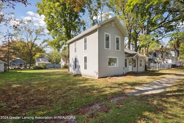 rear view of property with a lawn