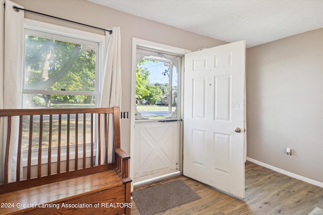 doorway to outside featuring a textured ceiling and hardwood / wood-style floors