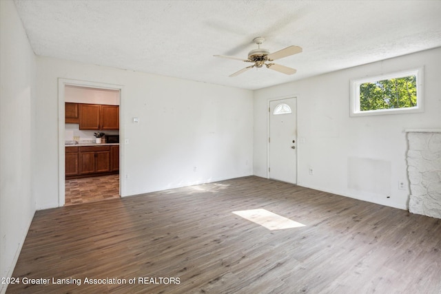 interior space with ceiling fan, a textured ceiling, and hardwood / wood-style floors