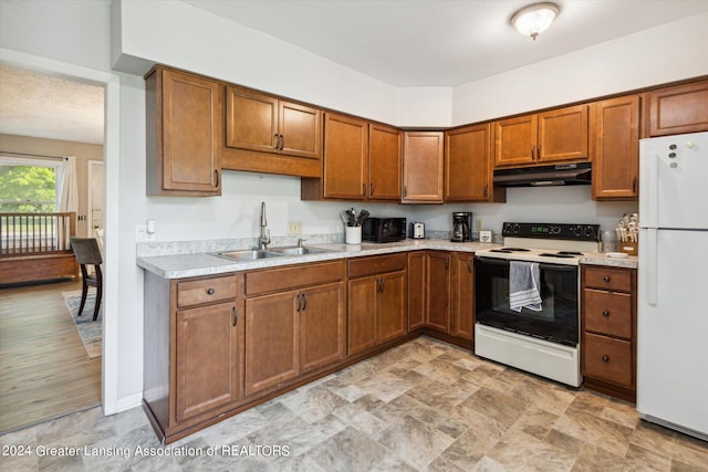 kitchen featuring light wood-type flooring, white appliances, and sink