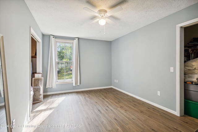 unfurnished room featuring a textured ceiling, ceiling fan, and hardwood / wood-style flooring