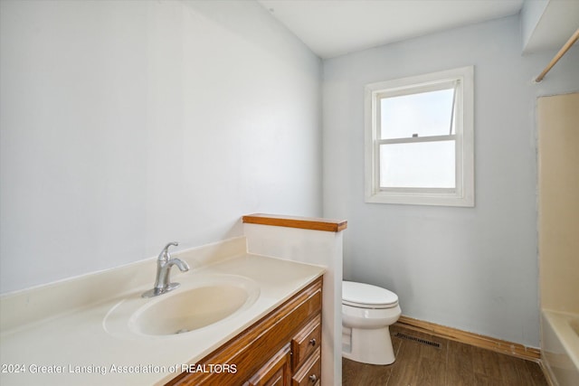 full bathroom with shower / tub combination, vanity, toilet, and hardwood / wood-style flooring