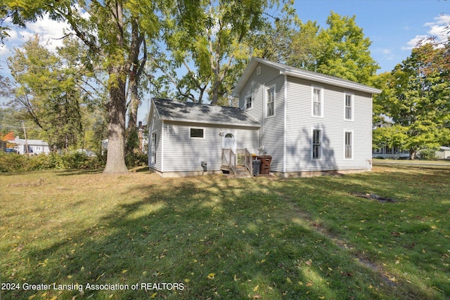 rear view of house featuring a lawn