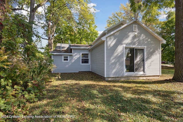 rear view of property featuring a yard