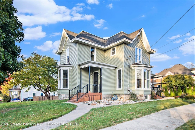 view of front of home with a front yard and central AC