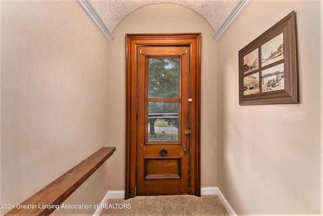 doorway with carpet and ornamental molding