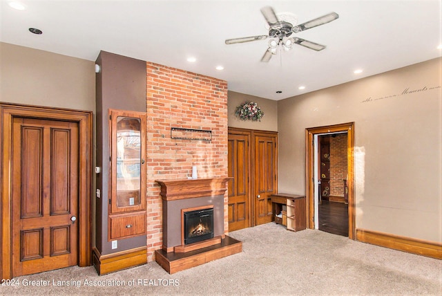 living room featuring light carpet, a fireplace, and ceiling fan