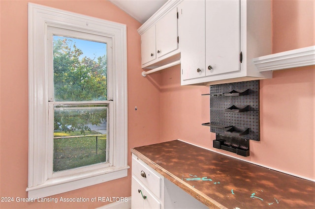 kitchen featuring vaulted ceiling and white cabinets