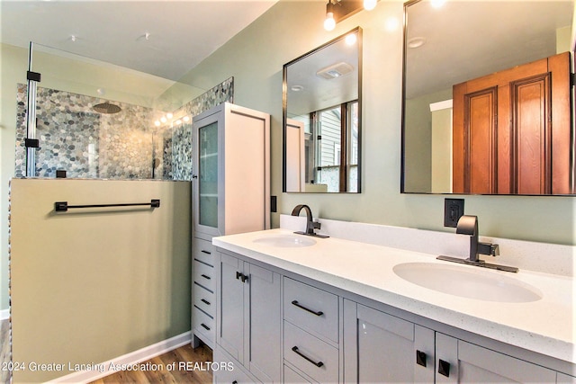 bathroom with vanity, hardwood / wood-style flooring, and a tile shower