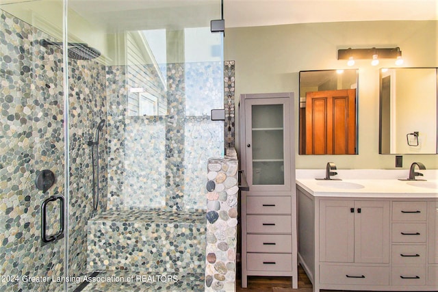 bathroom featuring a shower with door and vanity