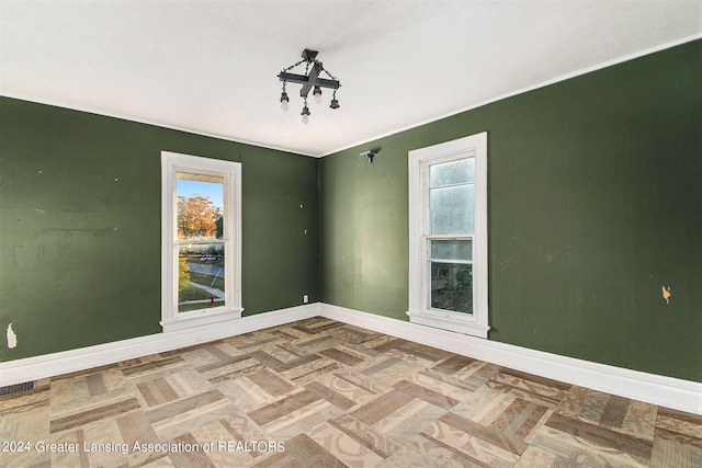 empty room featuring parquet floors and a healthy amount of sunlight