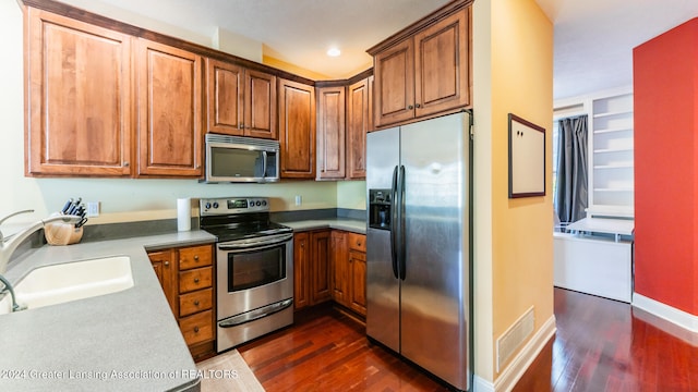 kitchen featuring stainless steel appliances, dark wood-type flooring, and sink