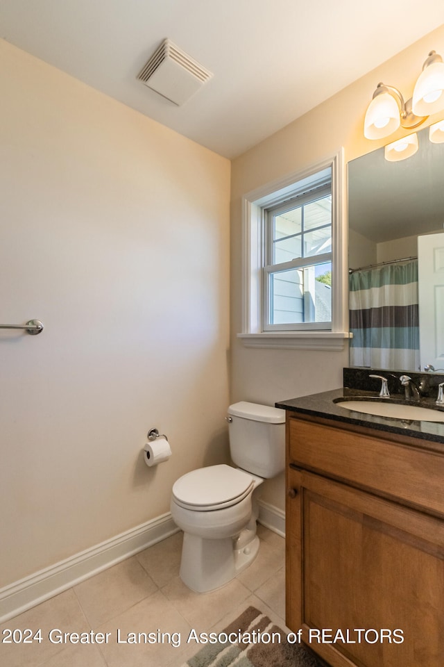 bathroom featuring vanity, tile patterned flooring, and toilet