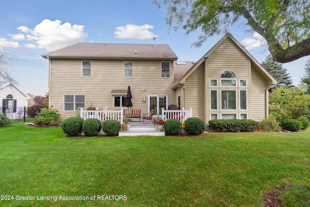 rear view of house with a lawn and a deck