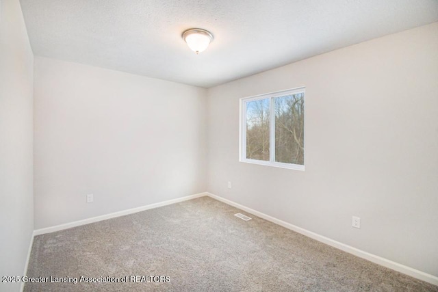 carpeted spare room featuring a textured ceiling