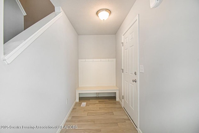 mudroom with a textured ceiling and light hardwood / wood-style flooring