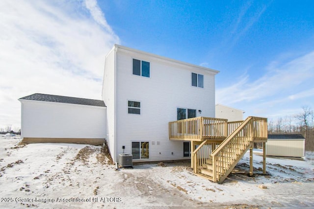 snow covered house with a wooden deck and central AC