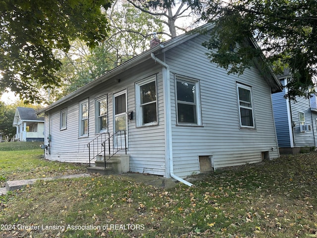 view of side of home with a lawn and cooling unit