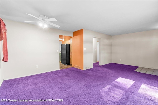 carpeted spare room with ceiling fan