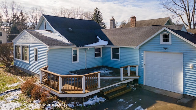 back of house with a garage and a wooden deck