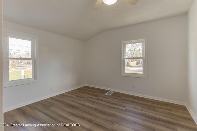 spare room featuring dark hardwood / wood-style flooring, a wealth of natural light, lofted ceiling, and ceiling fan