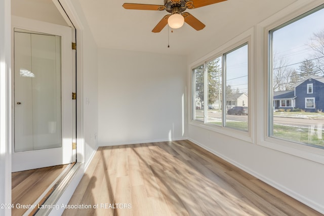 unfurnished sunroom featuring ceiling fan