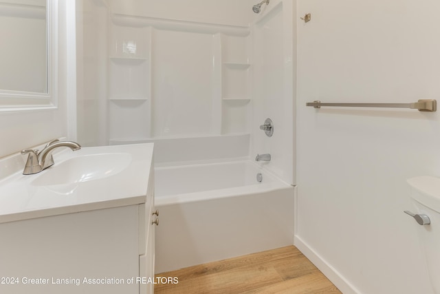 full bathroom with hardwood / wood-style floors, vanity, shower / bath combination, and toilet