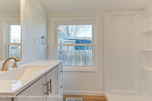 bathroom featuring a shower, hardwood / wood-style floors, and vanity