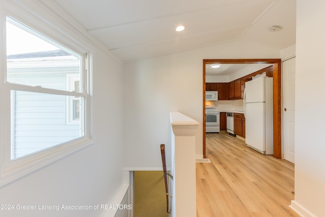 hall with light hardwood / wood-style flooring and lofted ceiling