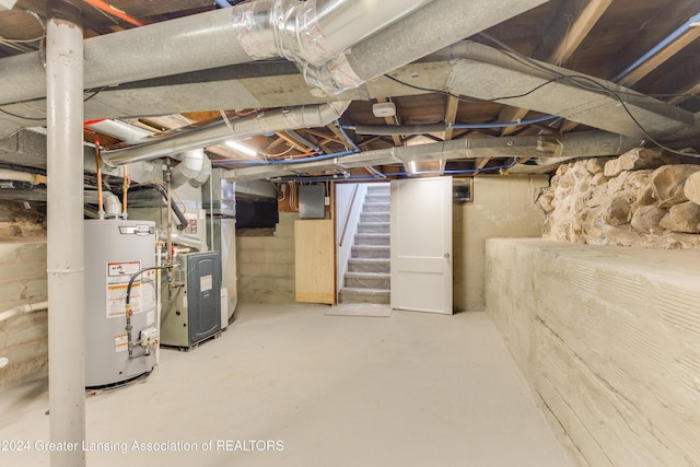 basement with electric panel, heating unit, and water heater