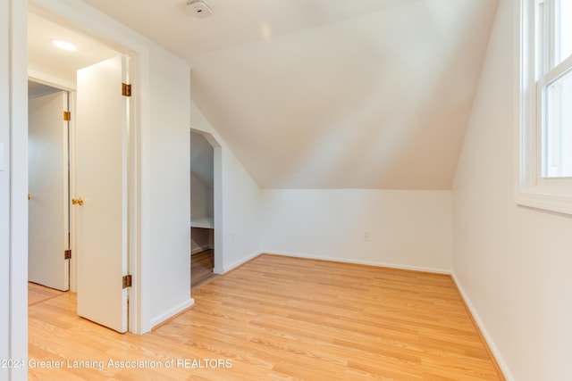 bonus room with light hardwood / wood-style floors and vaulted ceiling