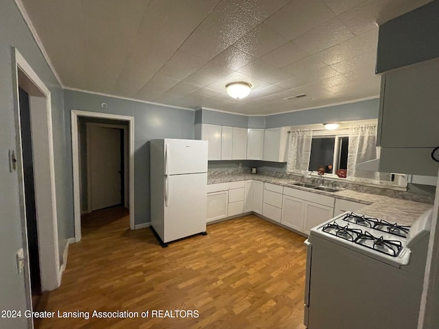 kitchen featuring sink, ornamental molding, white cabinetry, light wood-type flooring, and white appliances