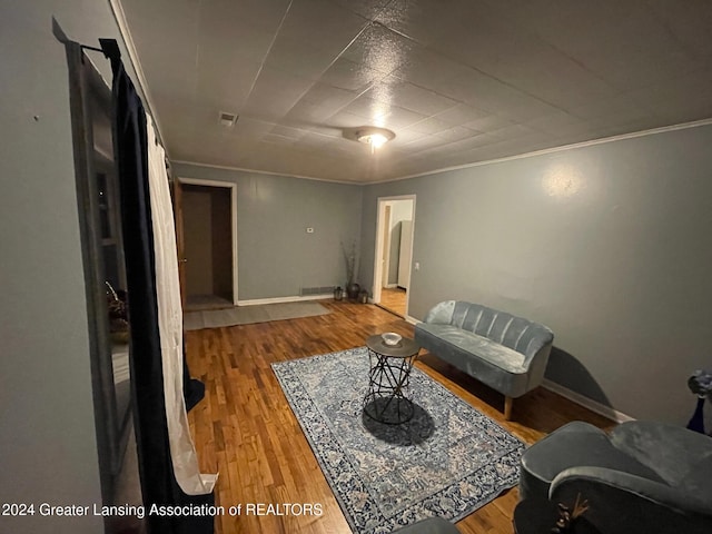 living room with wood-type flooring and crown molding