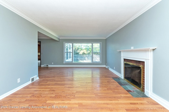 unfurnished living room with light wood-type flooring, a fireplace, and crown molding