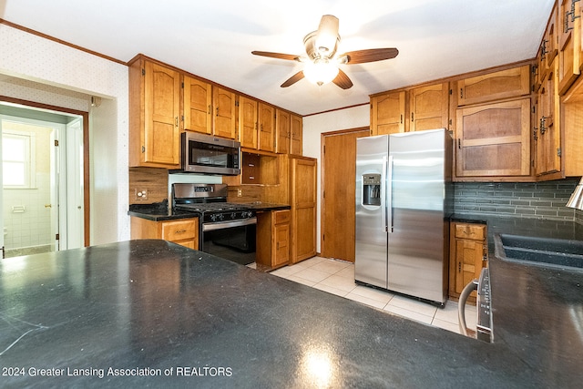 kitchen with ceiling fan, sink, light tile patterned flooring, appliances with stainless steel finishes, and backsplash